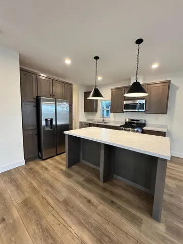 a kitchen with stainless steel appliances granite countertop a sink a stove and a refrigerator