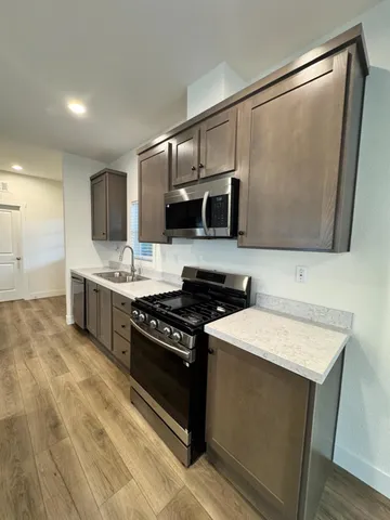 a kitchen with stainless steel appliances a sink stove and microwave