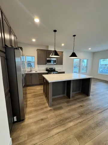 a kitchen with stainless steel appliances granite countertop a sink a stove and a refrigerator