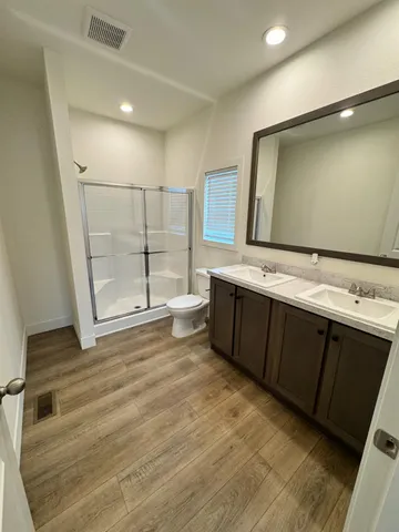 a view of a kitchen with stainless steel appliances wooden floor