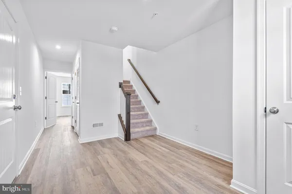 a view of a hallway with wooden floor and staircase