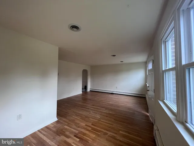 a view of an empty room with wooden floor