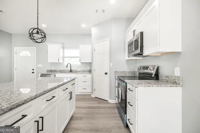 an open white kitchen with a sink and dishwasher with kitchen countertops