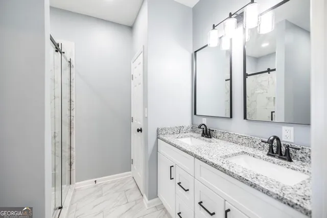 a bathroom with a granite countertop sink double and mirror