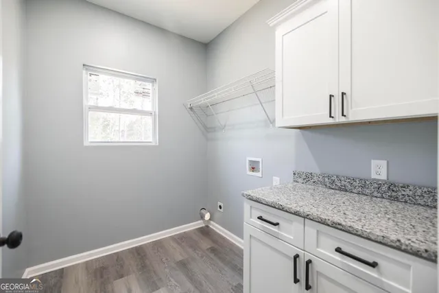 a view of granite countertop white cabinets and a wooden floor