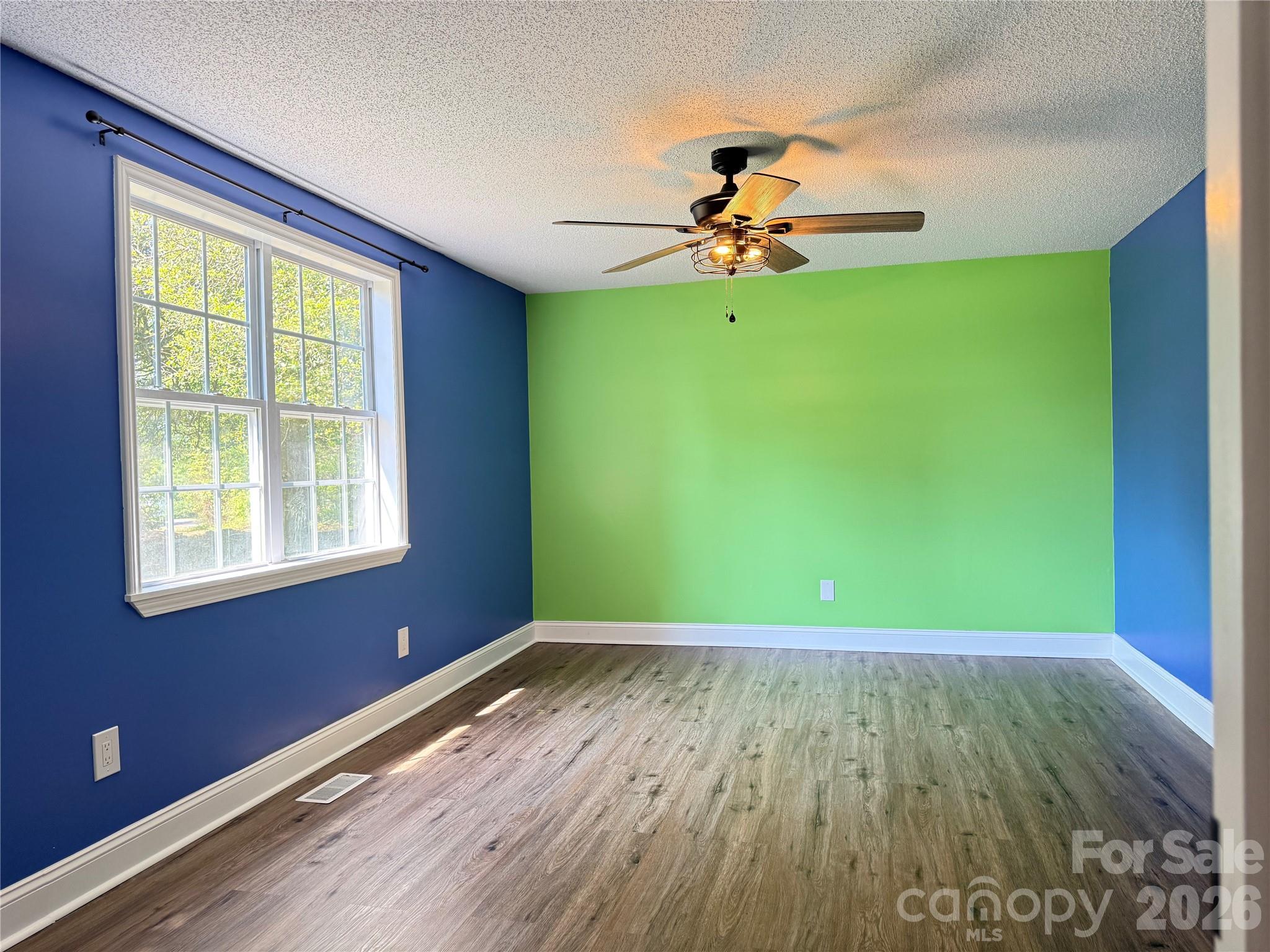 1442 Lee Pearson Road Granite Falls, NC 28630 - Photo 15 of 40 a view of an empty room with window ceiling fan and hardwood floor