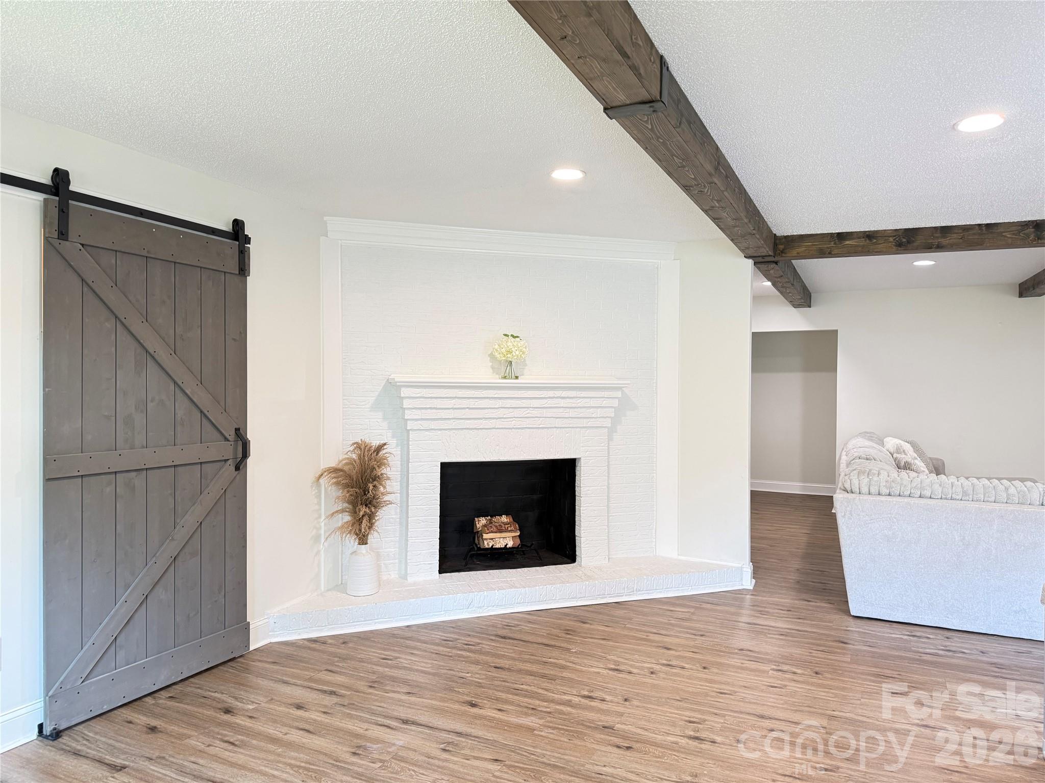 1442 Lee Pearson Road Granite Falls, NC 28630 - Photo 3 of 40 a view of an empty room with wooden floor and a fireplace