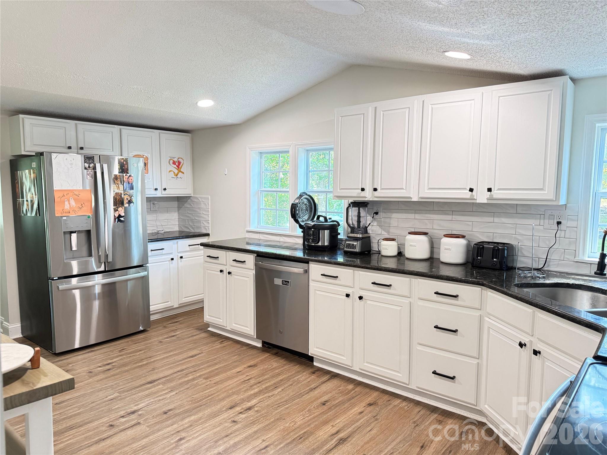 1442 Lee Pearson Road Granite Falls, NC 28630 - Photo 9 of 40 a kitchen with granite countertop white cabinets and white appliances