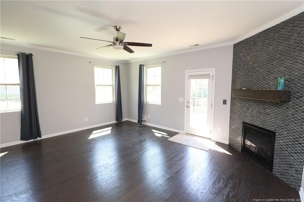 689 Wickham Ridge Road Apex, NC 27539 - Photo 11 of 37 an empty room with wooden floor fireplace and windows