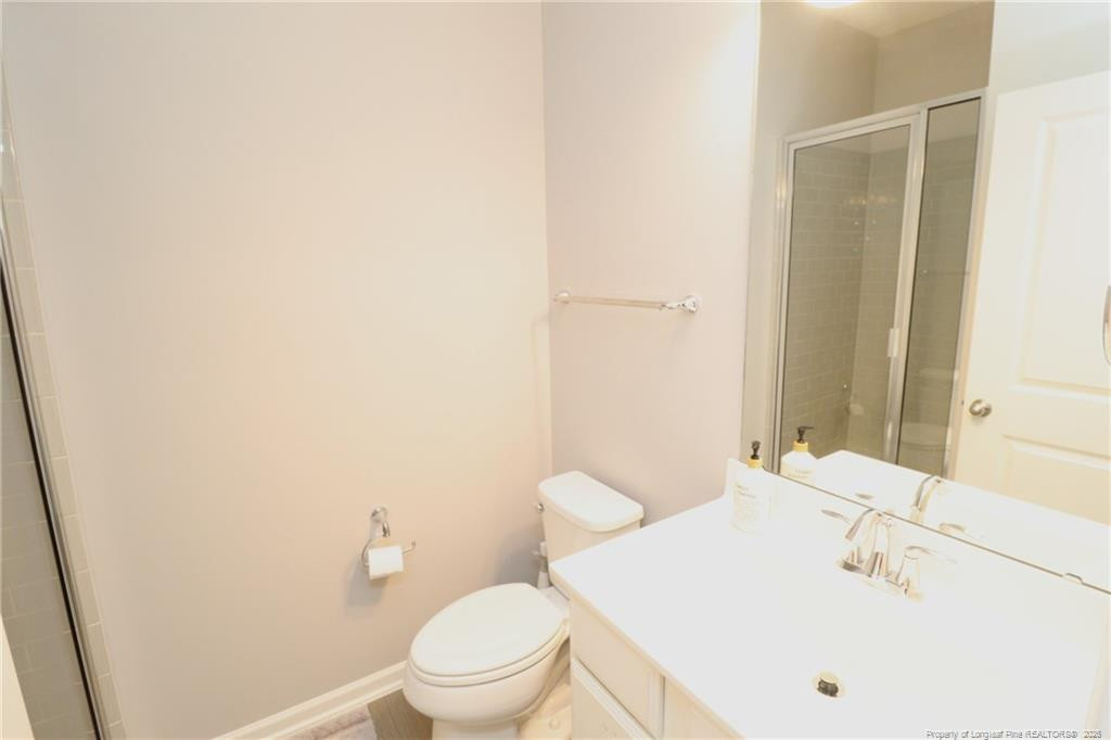 689 Wickham Ridge Road Apex, NC 27539 - Photo 17 of 37 a bathroom with a sink a toilet and shower