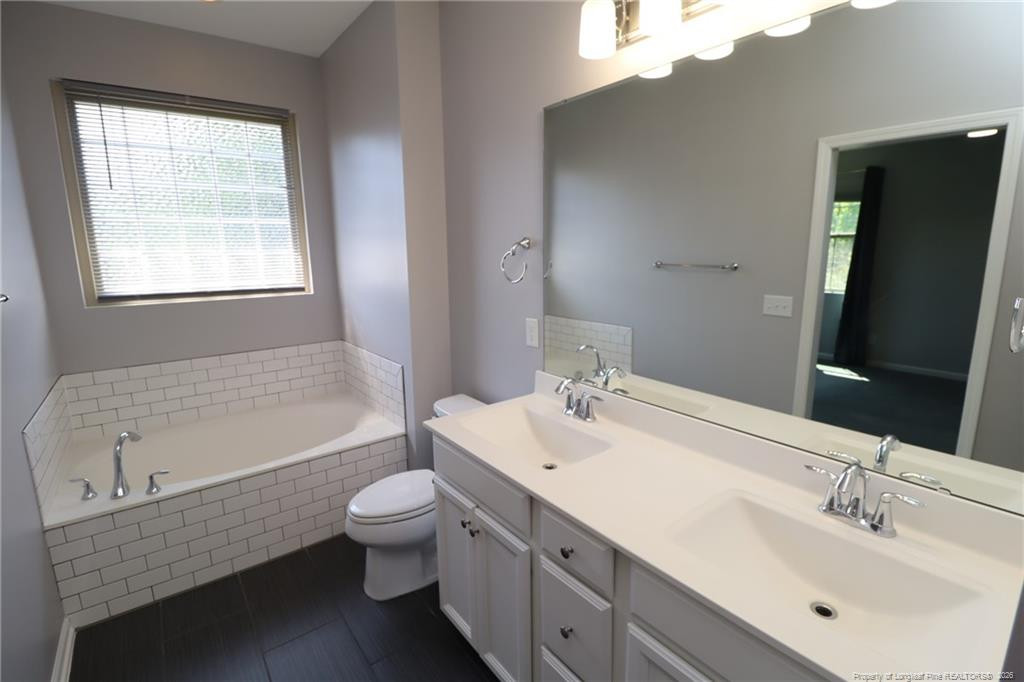 689 Wickham Ridge Road Apex, NC 27539 - Photo 26 of 37 a bathroom with a sink a toilet and shower