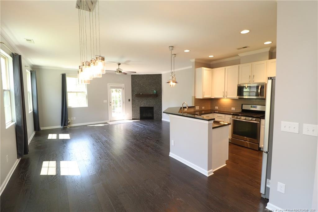 689 Wickham Ridge Road Apex, NC 27539 - Photo 3 of 37 a kitchen with a refrigerator and a stove top oven