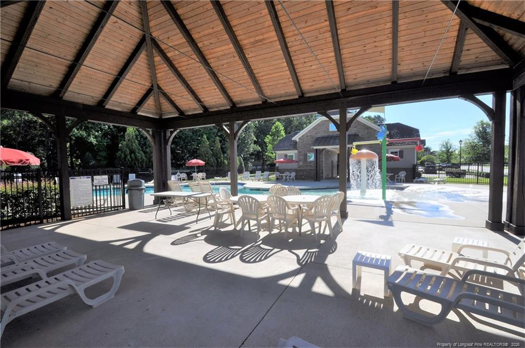 689 Wickham Ridge Road Apex, NC 27539 - Photo 36 of 37 a view of a patio with a table and chairs under an umbrella with a roof