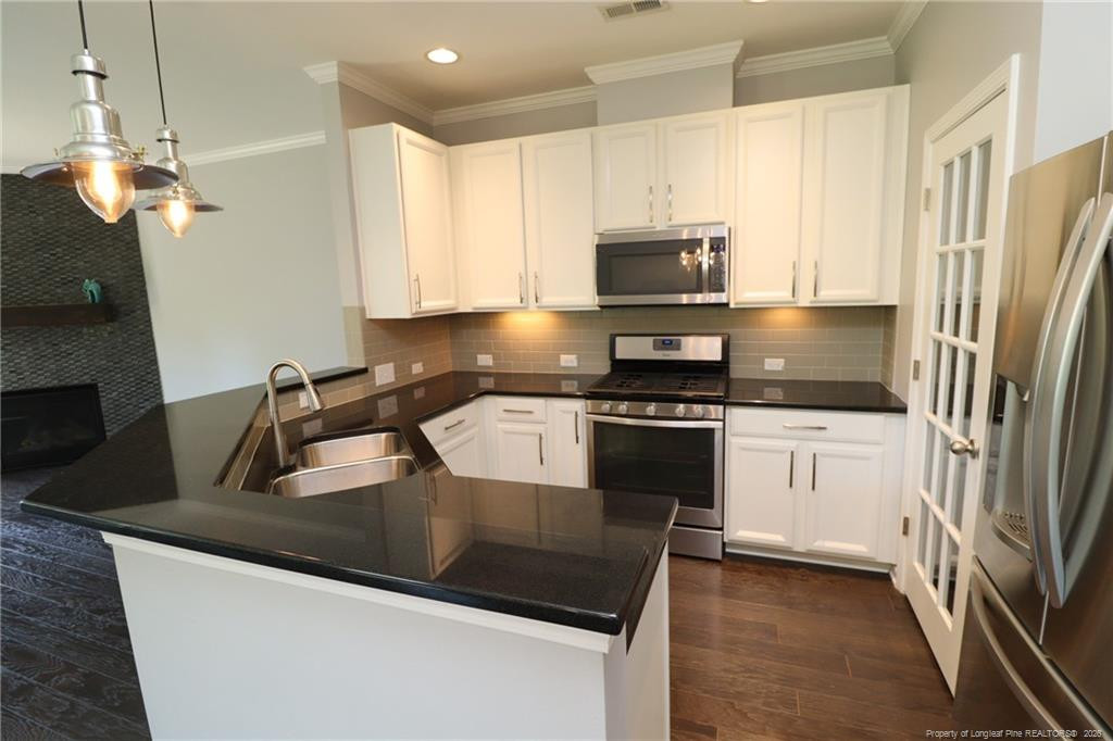 689 Wickham Ridge Road Apex, NC 27539 - Photo 4 of 37 a kitchen with granite countertop a refrigerator a sink a stove a microwave and island
