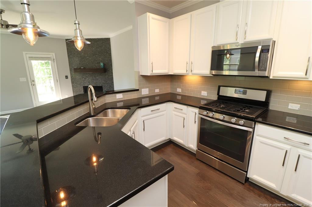 689 Wickham Ridge Road Apex, NC 27539 - Photo 6 of 37 a kitchen with a sink stove and microwave