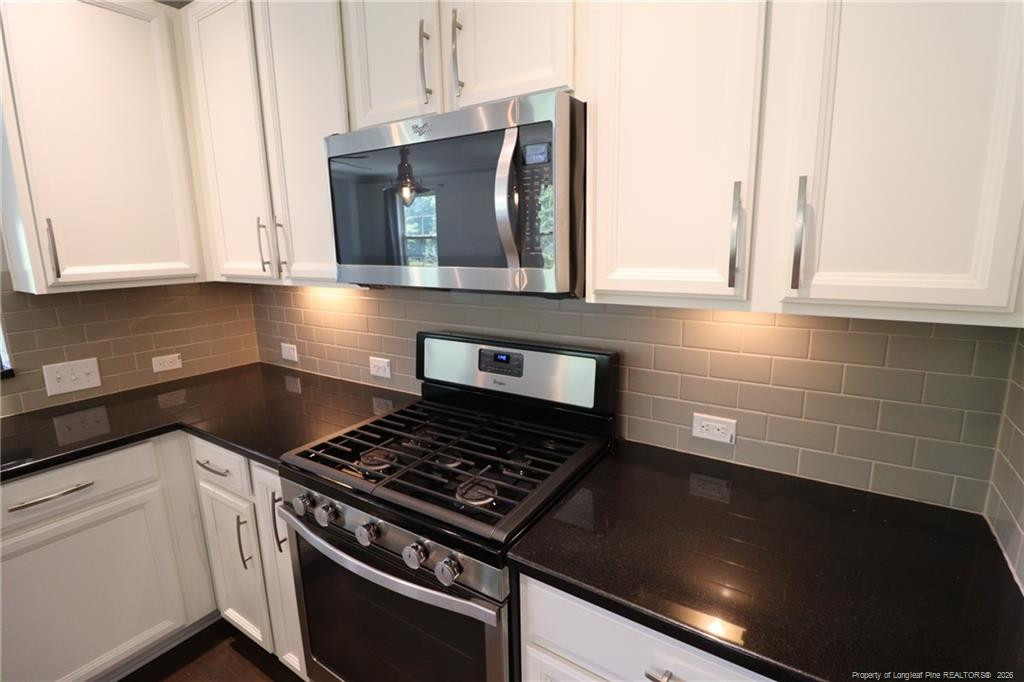 689 Wickham Ridge Road Apex, NC 27539 - Photo 8 of 37 a kitchen with granite countertop a stove and a microwave