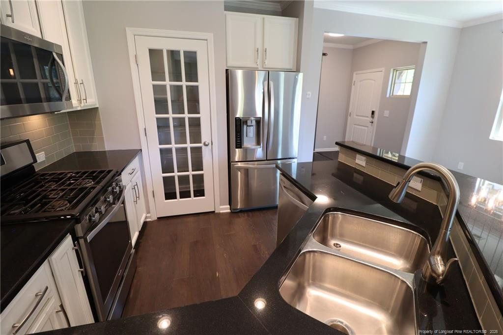689 Wickham Ridge Road Apex, NC 27539 - Photo 9 of 37 a view of a kitchen with refrigerator and wooden floor