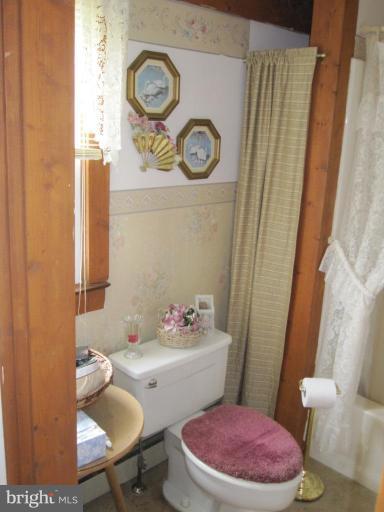 5201 Teeter Road Taneytown, MD 21787 - Photo 10 of 16 a white toilet sitting next to a bathroom sink and vanity