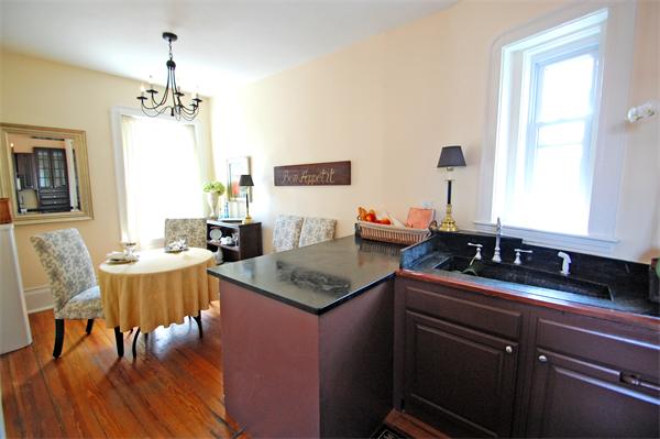 145 Charles Street, Unit 4 Boston, MA 02114 - Photo 6 of 14 a kitchen with a counter space dining table and chairs