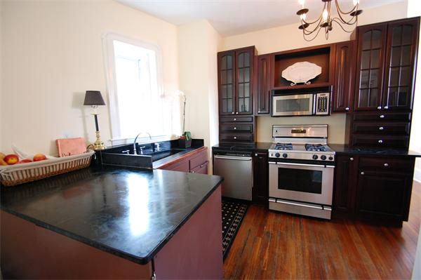 145 Charles Street, Unit 4 Boston, MA 02114 - Photo 7 of 14 a kitchen with stainless steel appliances a stove a microwave a sink and cabinets