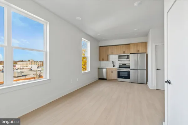 a kitchen with stainless steel appliances a refrigerator and a window