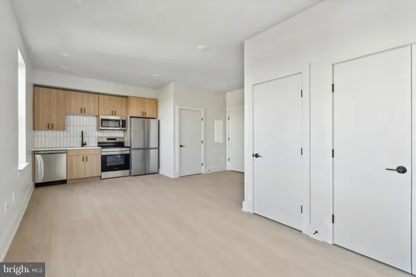 a view of a kitchen with a sink and dishwasher a refrigerator with white cabinets