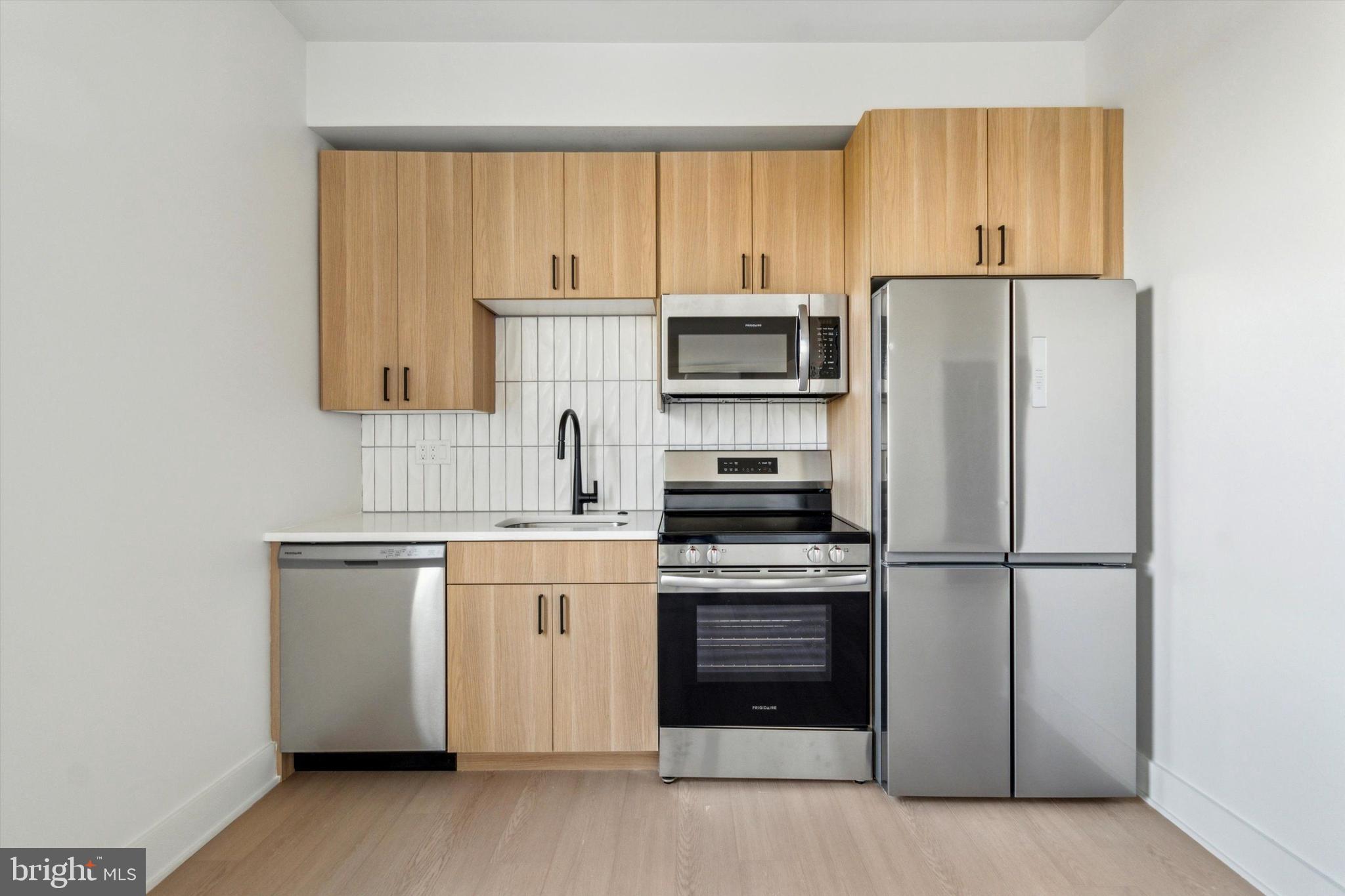 5521 Wayne Avenue, Unit 502 Philadelphia, PA 19144 - Photo 5 of 16 a kitchen with appliances cabinets and a sink