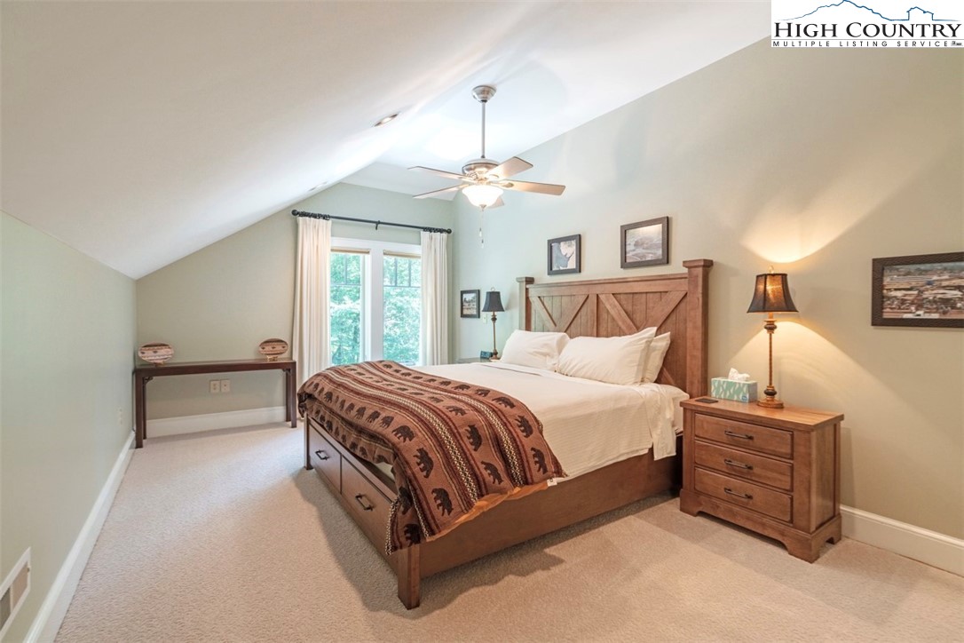 443 Echota Parkway, Unit 9B Boone, NC 28607 - Photo 25 of 43 a spacious bedroom with a bed and a chandelier