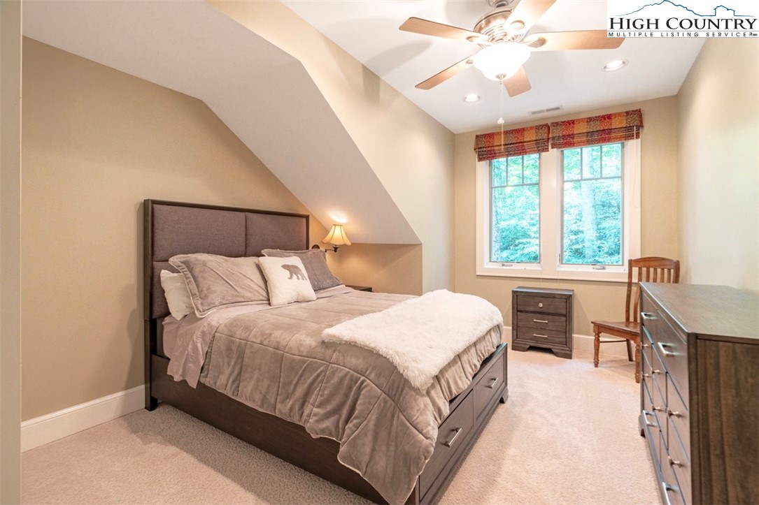 443 Echota Parkway, Unit 9B Boone, NC 28607 - Photo 29 of 43 a bedroom with a large bed and a chandelier