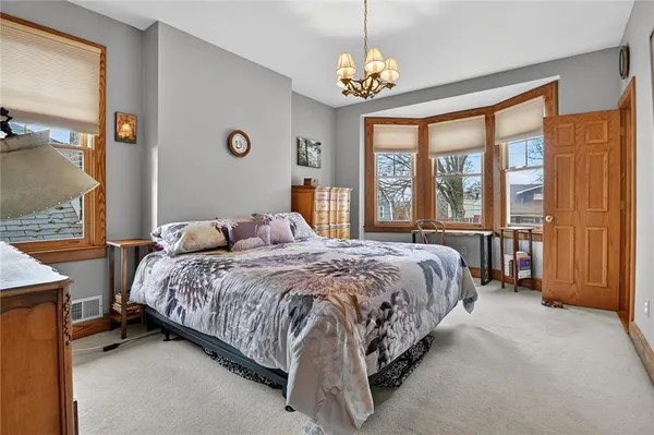 a spacious bedroom with a bed and a chandelier