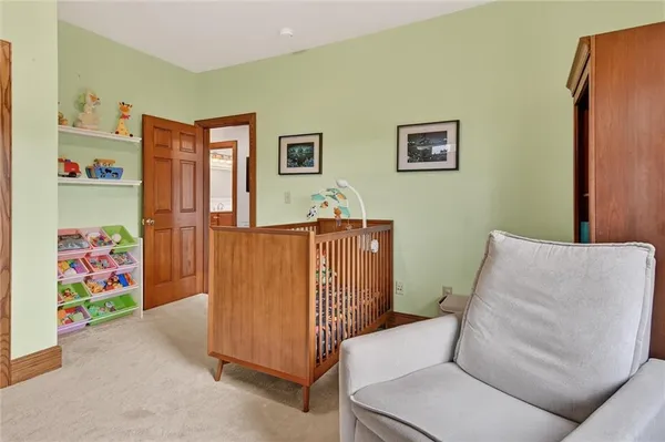 a living room with furniture and a baby crib