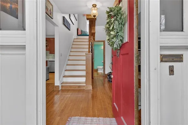 a view of a hallway with wooden floor and stairs