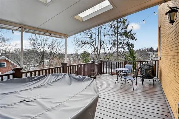 a roof deck with table and chairs and wooden floor