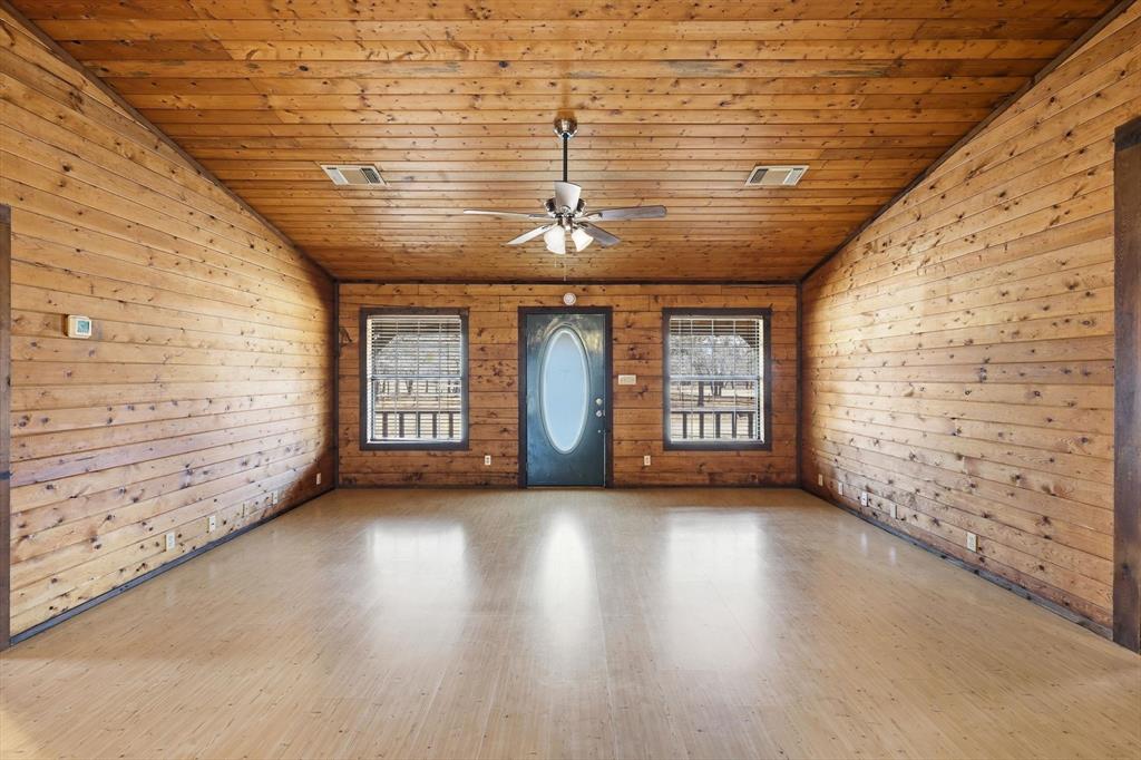 504 Windsor Lane Springtown, TX 76082 - Photo 8 of 40 a view of an empty room with wooden floor and a window