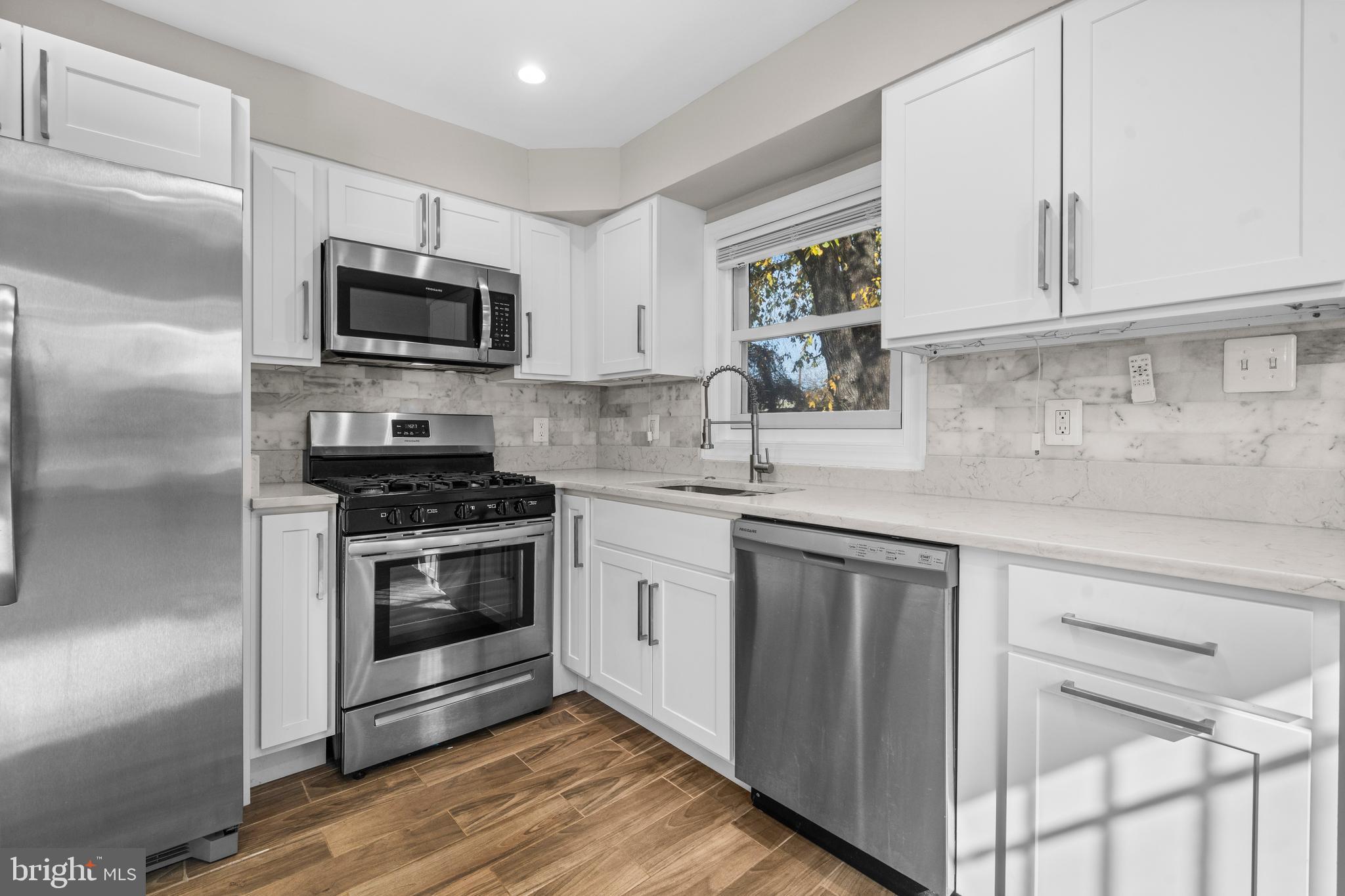 4314 Wheeler Road Southeast Washington, DC 20032 - Photo 12 of 36 a kitchen with white cabinets stainless steel appliances and sink