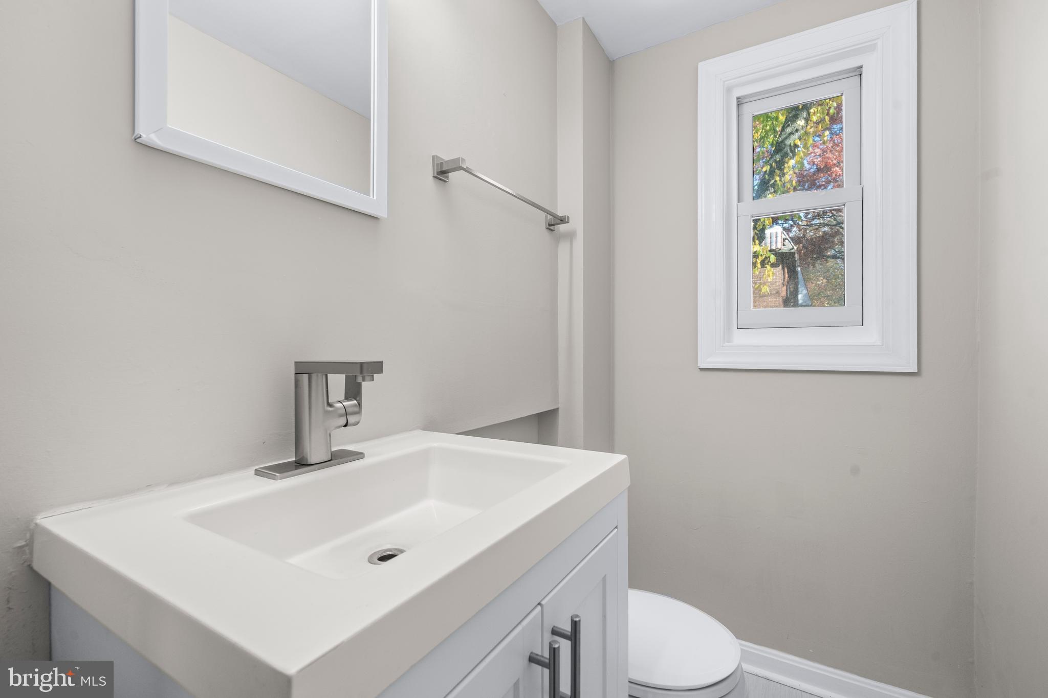 4314 Wheeler Road Southeast Washington, DC 20032 - Photo 13 of 36 a bathroom with a sink a toilet and mirror