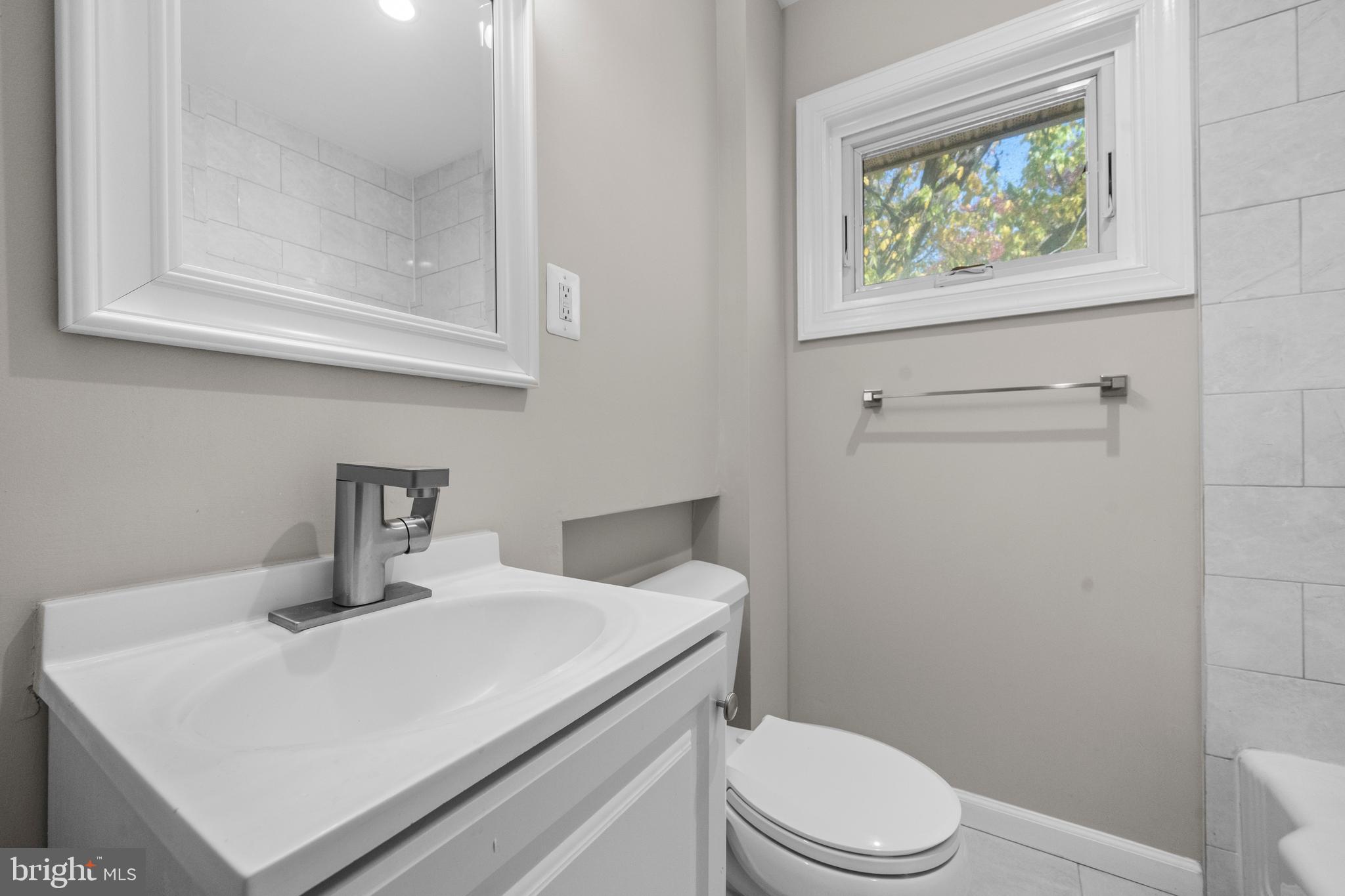 4314 Wheeler Road Southeast Washington, DC 20032 - Photo 21 of 36 a bathroom with a toilet a sink and mirror