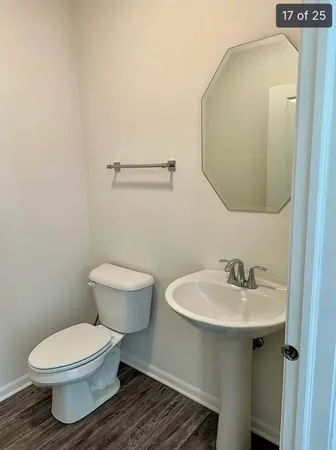 a bathroom with a toilet a sink and mirror