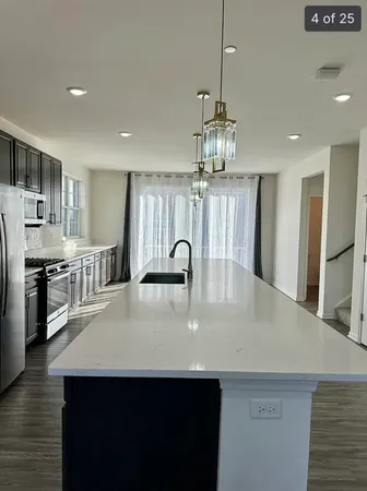 a large kitchen with stainless steel appliances granite countertop a lot of counter space cabinets and wooden floor