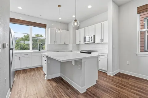 a kitchen with a sink window and cabinets