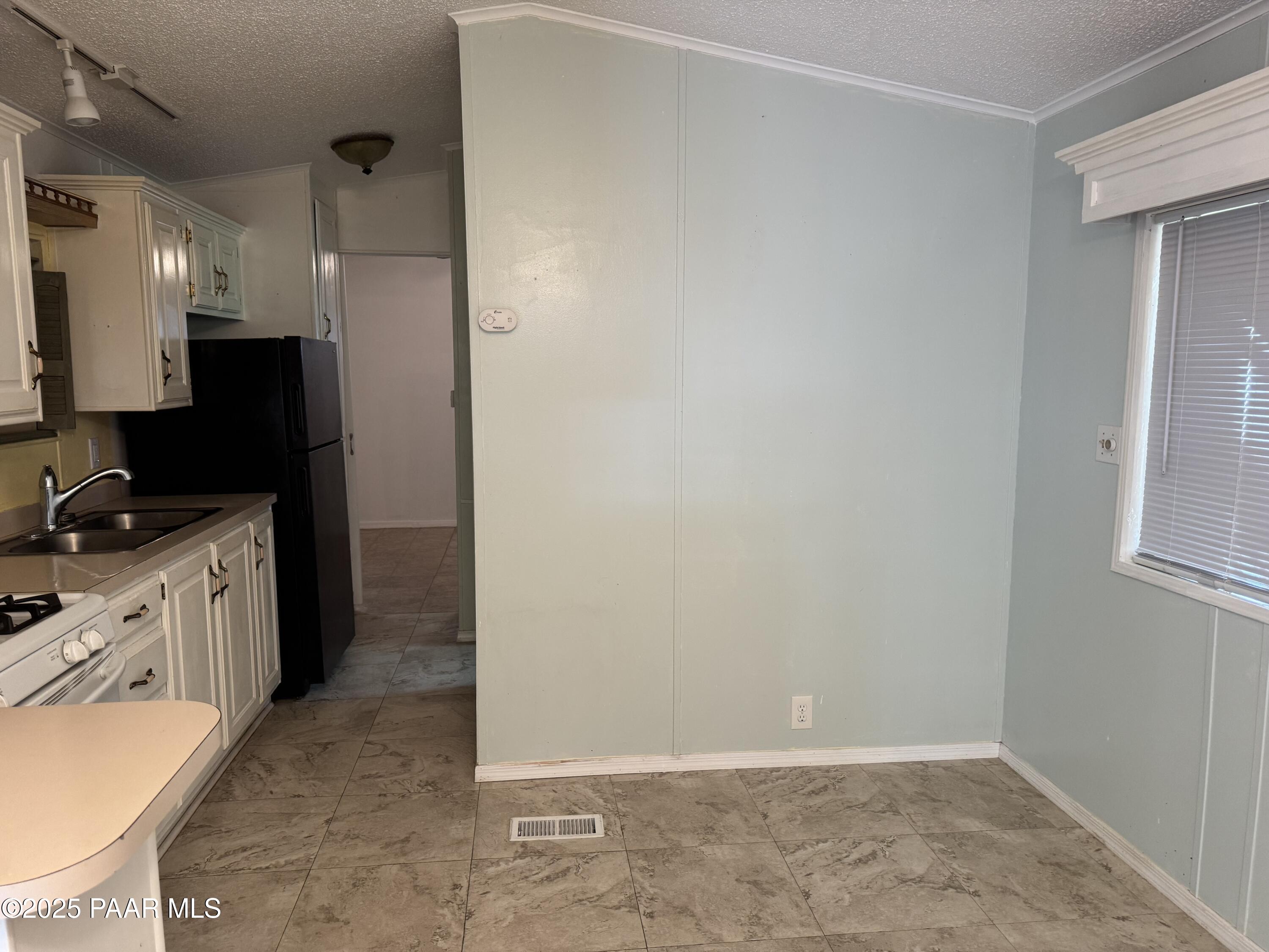 11250 East State Rte 69, Unit 80 Prescott Valley, AZ 86314 - Photo 6 of 13 a view of a kitchen with refrigerator and wooden floor