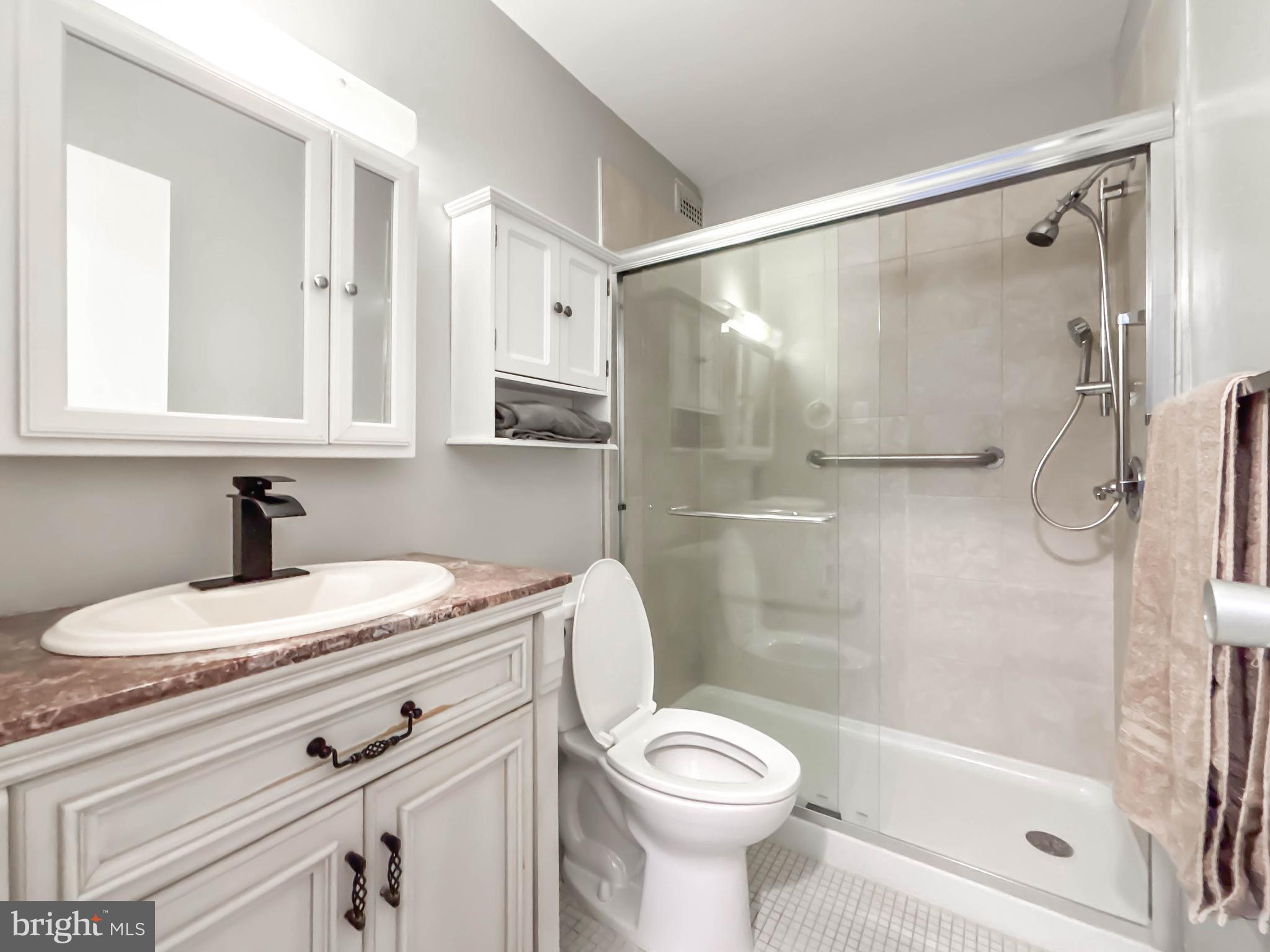 130 Slade Avenue, Unit 414 Baltimore, MD 21208 - Photo 35 of 48 a bathroom with a sink a toilet and shower