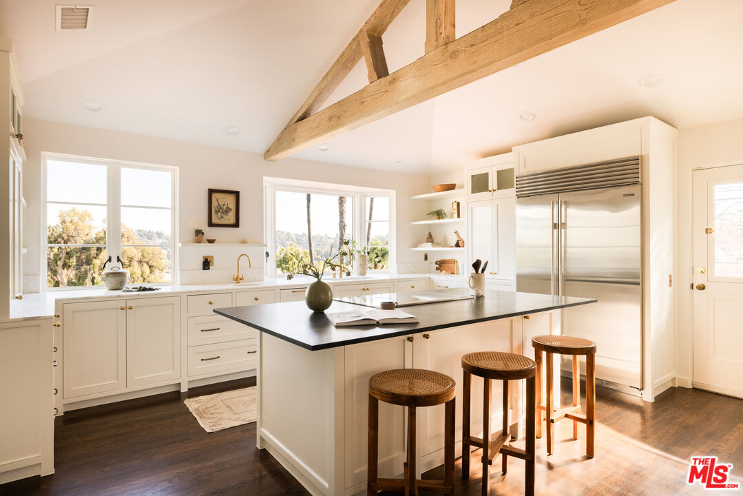 2226 Moreno Drive Los Angeles, CA 90039 - Photo 14 of 65 a kitchen with stainless steel appliances granite countertop a table chairs sink and cabinets