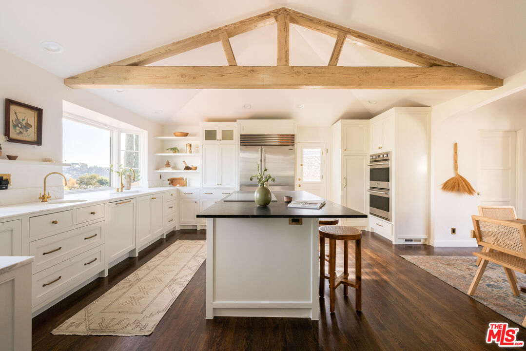 2226 Moreno Drive Los Angeles, CA 90039 - Photo 15 of 65 a kitchen with stainless steel appliances a table chairs in it and wooden floors