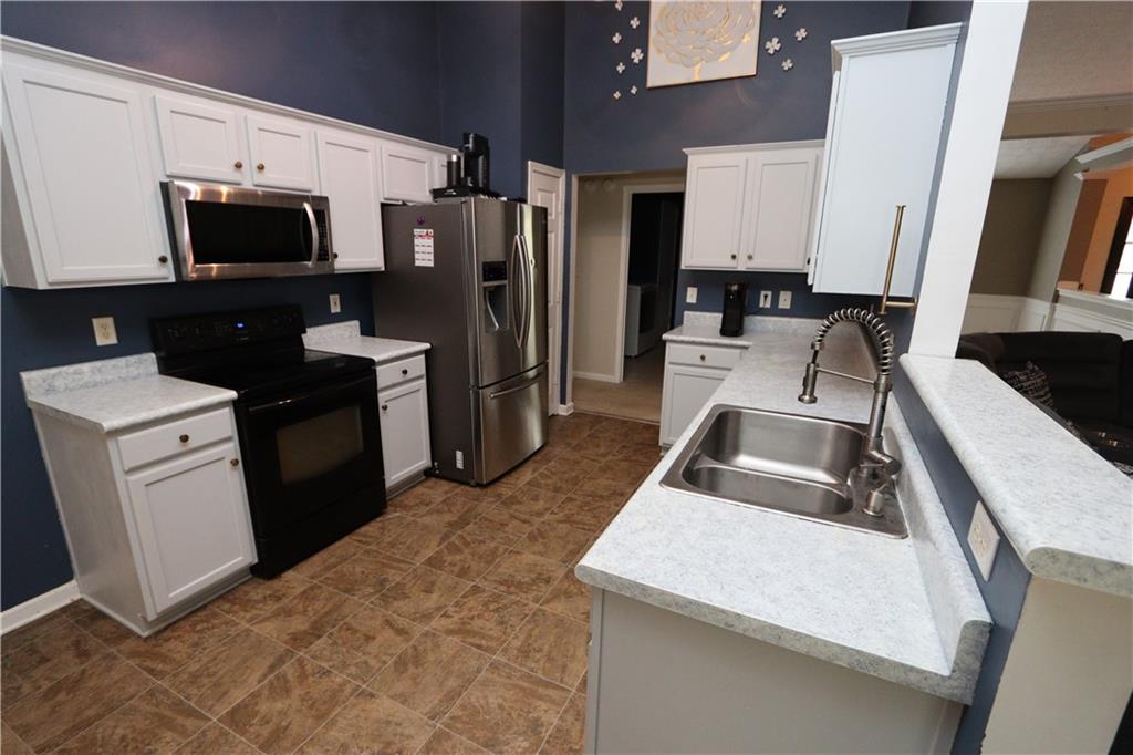 232 Harlan Heights Road Villa Rica, GA 30180 - Photo 3 of 9 a kitchen with a sink stove and refrigerator