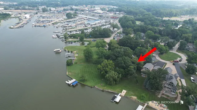 an aerial view of a house with a yard and lake view
