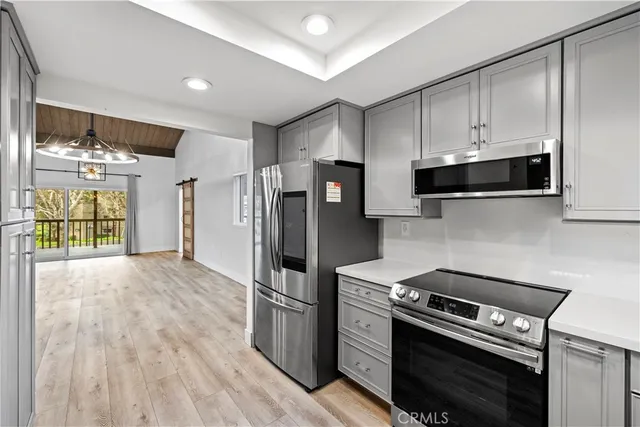 a kitchen with stainless steel appliances a stove a refrigerator and a cabinets