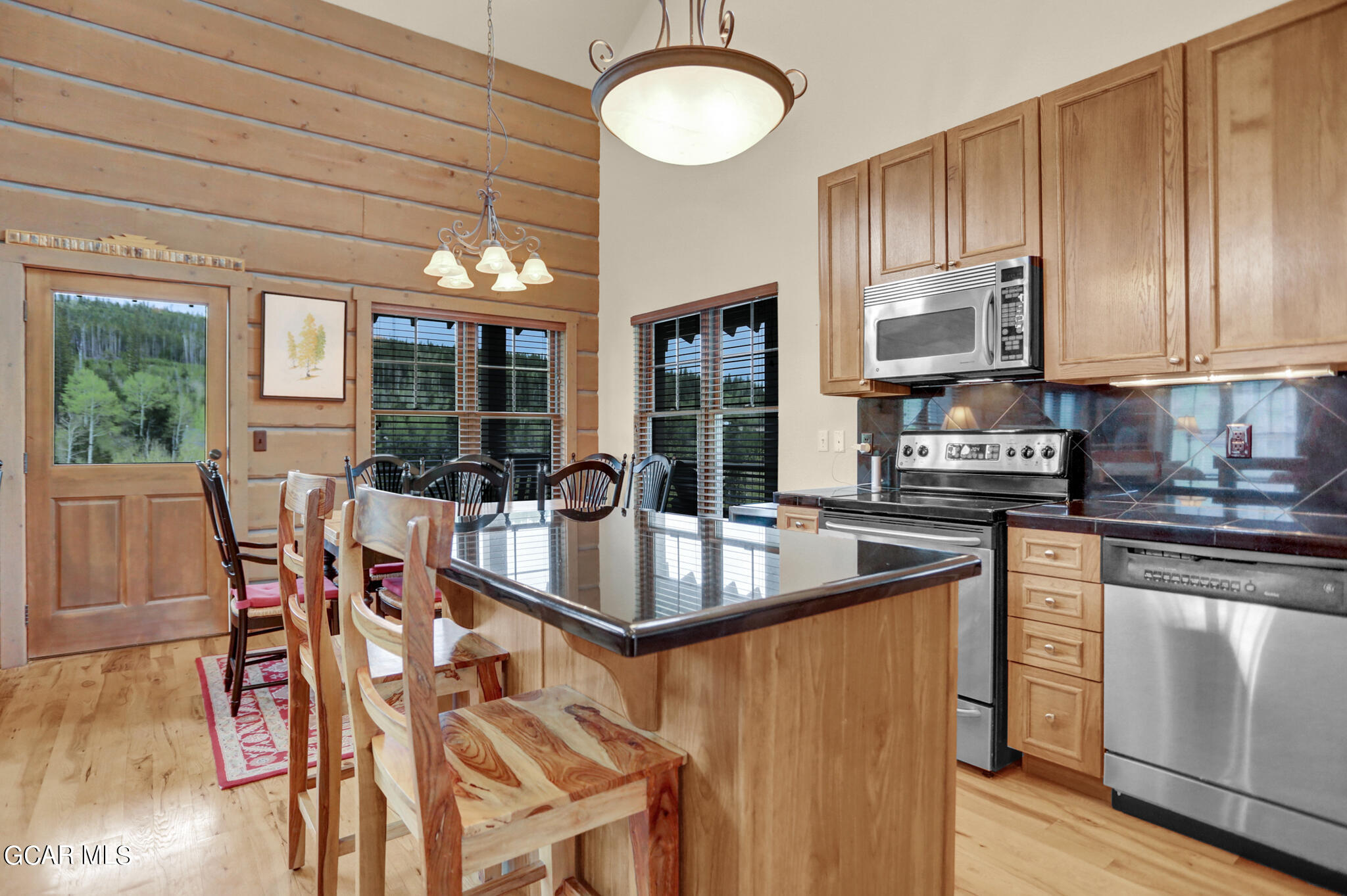 1180 Rendezvous Road Fraser, CO 80442 - Photo 5 of 44 a kitchen with stainless steel appliances granite countertop a stove top oven a sink dishwasher a dining table and chairs with wooden floor
