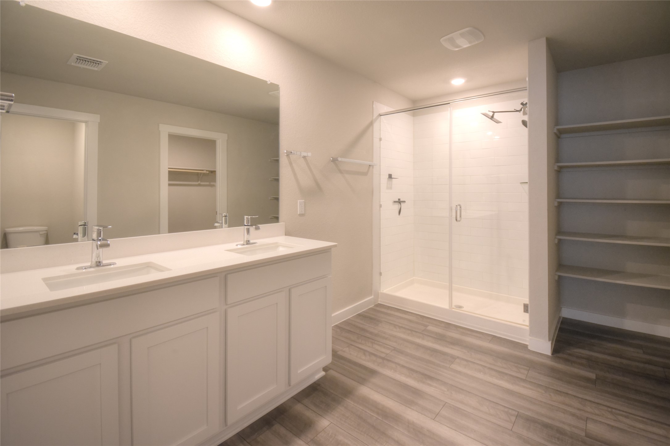 1137 Tipton Street Georgetown, TX 78633 - Photo 8 of 18 Bathroom with double vanity, a shower stall, light wood-type flooring, and a spacious closet