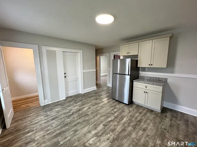 a kitchen with granite countertop a refrigerator and a sink